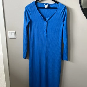 Ribbad klänning  - Blå ribbad klänning med knappar från Lindex. Använd en handfull gånger. Superfint skick. Passar även för gravida  