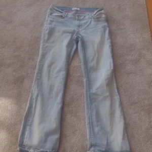 Blåa jeans med rosa tyg innuti  - Låg midjad bootcut jeans med riven stil på botten