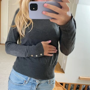Finstickad tröja - Säljer min fina fina tröja från Lindex Holly &Whyte. Guldknappar i ärmarna som går att öppna och stänga. Använd fåtal gånger😊nypris 399