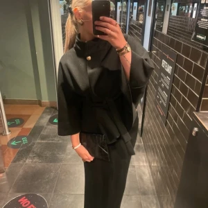 Kappa - svart kappa med gulddetalj 