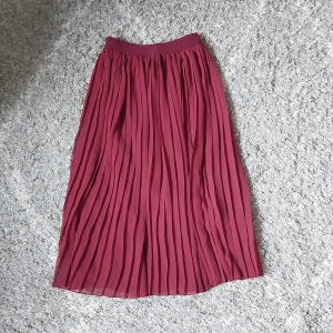 Vinröd plisserad kjol från NA-KD - Plisserad vinröd midikjol från NA-KD. Kjolen har en elastisk midja och är i storlek XS. Mycket somrig kjol som jag säljer då den är för liten för mig.