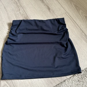 Kjol  - Marinblå kjol som sitter tight och har scrunch på sidorna, säljer även en matchande tröja köp båda för 120 kr 🥰
