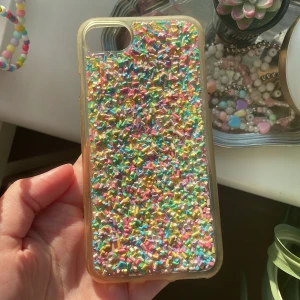 Mobilskal strössel - Mobilskal från pull and bear med regnbågsströssel på. Passar iPhone 7. Hårdplast