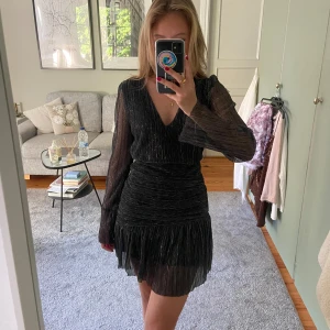 Glittrig mini klänning - Meet X Tiger - Svart, långärmad mini klänning från Meet x Tiger. Endast använd en gång så den är i fint skick!