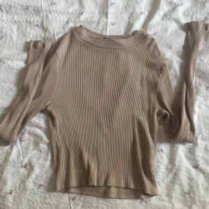 Croppad ribbad tröja - En beige tröja i en croppad-tajt passform, tröjan är från lager157 och är i storlek XS