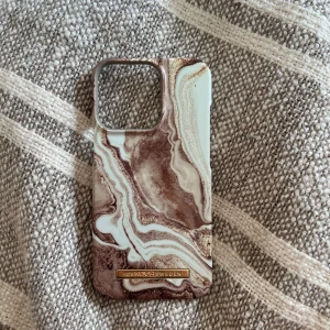 Mobilskal  - Brun/beiget mobilskal ifrån Ideal of Sweden. Skalet är till iPhone 13 Pro💓