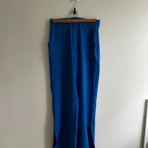 Blå kostymbyxor med slits - Väldigt fina kostymbyxor från stradivarius. De har en slits nere vid ankeln vilket är en så snygg detalj. Väldigt fin blå färg 