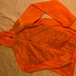 Orange träningsjacka från Adidas - Säljer en snygg och sportig orange träningsjacka från Adidas. Jackan har en dragkedja framtill och är långärmad. Perfekt för löpning eller annan träning. Den är i storlek S och är i mycket bra skick. Passar perfekt för vår och höstträning!