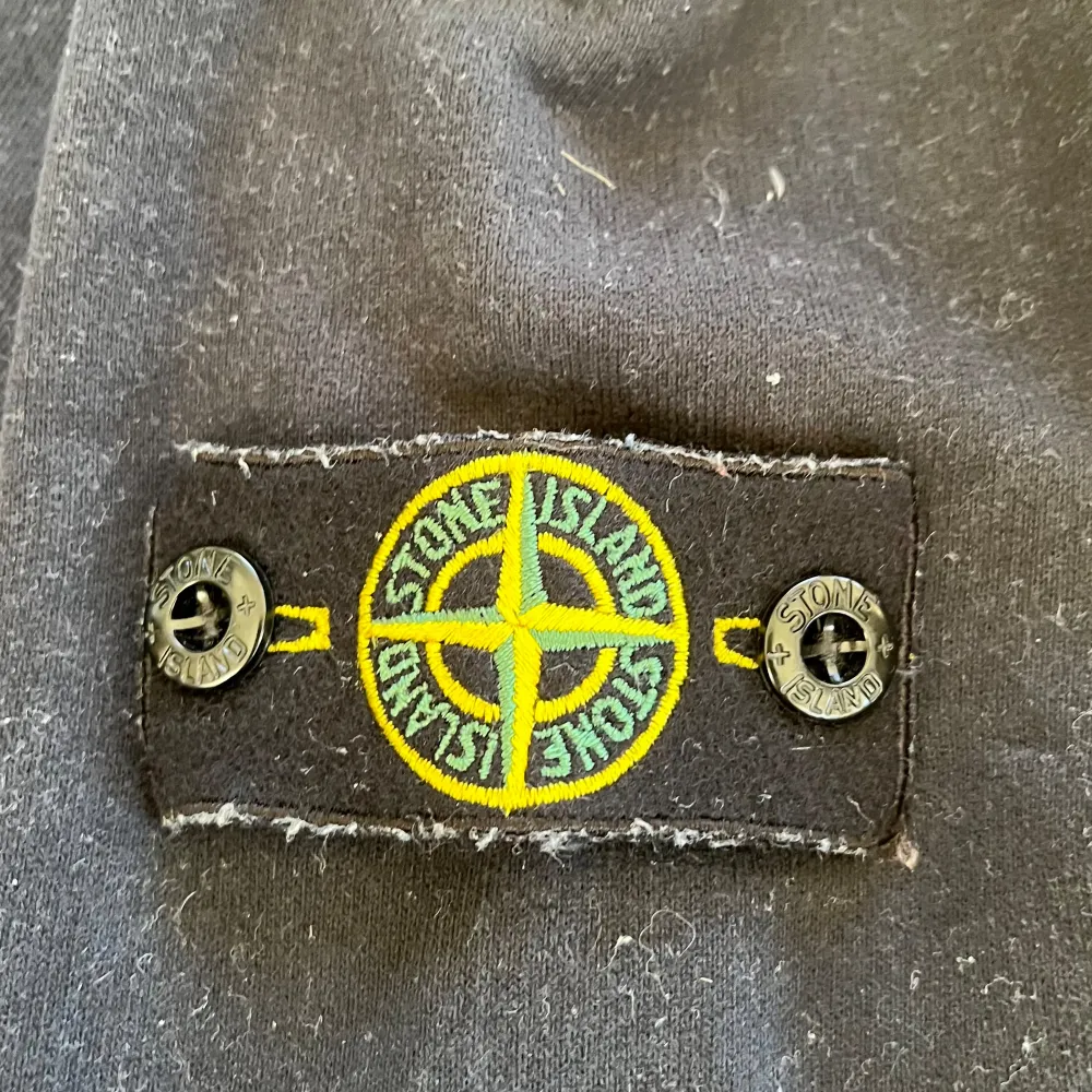 Snygg Mörkblå Stone Island-hoodie i toppskick! Passar perfekt för dig som är 165-175 cm lång. Ursprungligen köpt för 2200 kr, nu tillgänglig för endast 1400 kr (priset kan diskuteras). Nästan oanvänd och äkta med QR-kod och extra knapp inkluderad.. Hoodies.