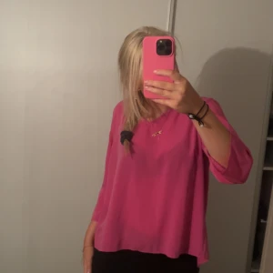 Rosa blus med öppen rygg - Säljer en superfin rosa blus med öppen rygg. Den är perfekt för både vardag och fest. Blusen har en lös passform och trekvartsärmar. Materialet känns lätt och luftigt, vilket gör den bekväm att bära hela dagen.