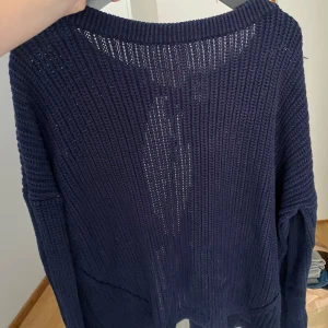 Mörkblå stickad tröja - Väldigt fin mörkblå stickad tröja med öppen rygg samt knyten🥰 Från Next storlek S.