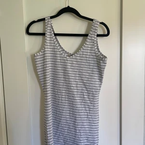Randig ärmlös klänning - Säljer en superfint linne i storlek M. Den är ärmlös och har en v-ringad hals. Linnet  är i nyskick och har aldrig använts, lappen sitter fortfarande kvar. Materialet känns mjukt och skönt mot huden.
