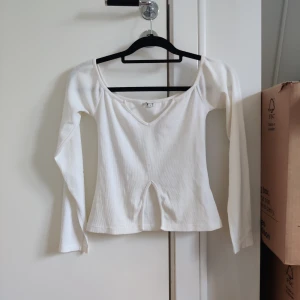 Vit långärmad tröja - Superfin topp från Nelly som är i jättefint skick. Den har slits vid ärmsluten och är i räfflat material.