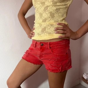 Lågmidjade jeans shorts  - Röda låga jeans shorts  Mått är  Midja rakt över 38 cm Längd från grenen & uppåt 29 cm