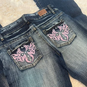 Lågmidjade jeans  - Lågmidjade bootcut jeans med coola rosa detaljer. Helt nya med lappen kvar! Storlek 27. Skriv för mått💕