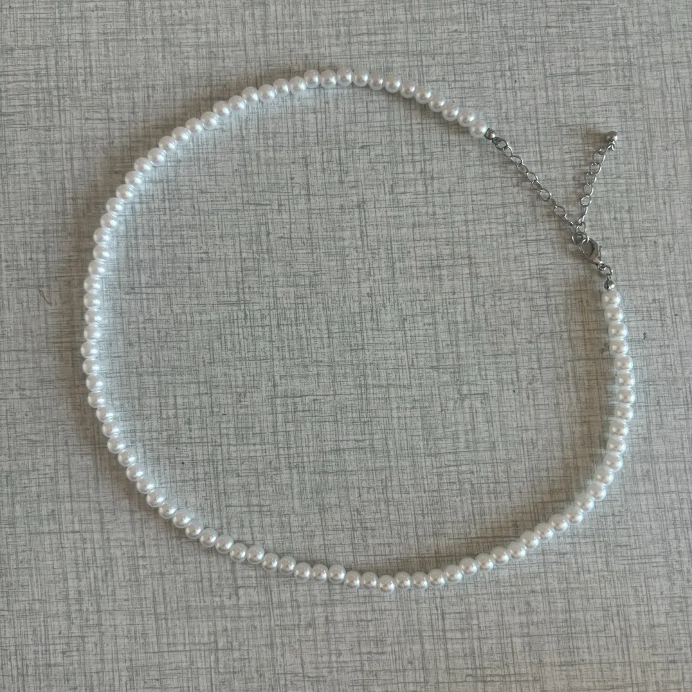 Ett fint vitt pärlhalsband som går att justera i storleken. Längsta längd är 57 cm och kortaste är 48 cm! I fint skick 💛. Accessoarer.