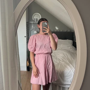 Rosa klänning  - Klänning från Nelly - NLY trend storlek 34 Med puffärm och knyt i ryggen perfekt till midsommar  I nyskick 