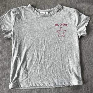 Fin grå t-shirt med Ma Cherie tryck från Gina Young som är köpt förra året, den är i storlek 158/164 som jag skulle säga passar en xs och den är i jättebra skick💘