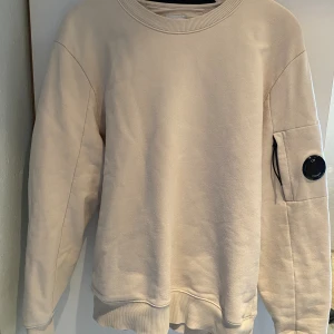 C.P Company tröja - Hej, säljer nu min C.P company sweatshirt som är för stor för mig. Den har en beige/vit färg med storleken small men passar medium. Inga defekter och är nästan sprillans. Nypris~2200kr Hör av er om ni har några frågor😁