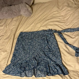 Blomstrig kjol - Fin sommarkjol med blommigt mönster, knytbar på sidan🌸 Storlek 40🌸 