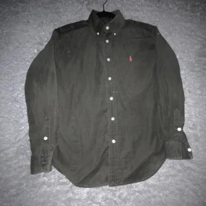 Ralph Lauren skjorta - En tvär fet Ralph Lauren skjorta som är perfekt nu till sommaren med ett schyst material. Aldrig använts och är inprincip helt ny. Storlek 12-14 år. Orginalpris: 1800kr