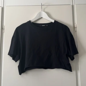 Croppad T-shirt  - Svart croppad T-shirt ifrån Bikbok i fint skick, storlek M men passar även S! Super fint med ett spets linne under!💗 (andra bilden är lånad men den sitter likadant på) 💗 skriv för fler bilder eller vid frågor! 