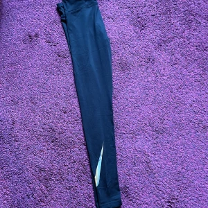 Träningstights nike - Svarta träningstights från Nike! Har tre likadana. Fint skick. Låga i midjan. Ficka baktill. Bock på benet. Lappen baktill är bortklippt. Pris diskuterbart ❤️