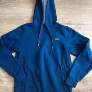 Hoddie Lacoste  - Mycket bra tillstånd  Lacoste Hoddie det enda felet är 2 fläckar på baksidan, huvan  täcker helt denna brist Lacoste Sport