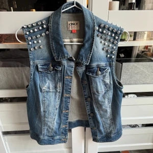Jeansväst med detaljer  - Något mindre i storlek. Står storlek 38 men skulle säga att det är en xs-s😀