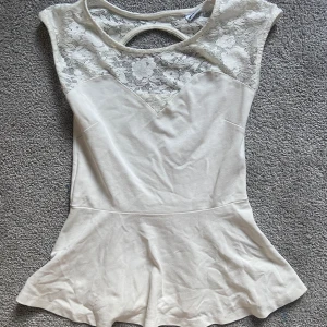 Vit topp/ vit t-shirt - En jättesöt vit topp/t-shirt ifrån ginatricot 💞 Den är vit med spets och en liten volangkjol!i storlek M🥰 Hör av er om ni undrar över något!