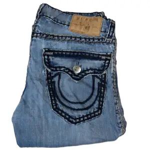 True Religion jeans Straight fit, Super QT stitch. W34. Saknar knapp på vänster bakficka och gylfen (bild 3) syns inte med bälte går också lätt att laga. [Ytterbenslängd 106cm] [Innerbenslängd 79cm] [Midja 44cm] [Benöppning 22cm]