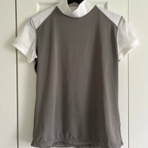 Ridkläder t-shirt  - Tävlings eller tränings t-shirt endast använd ett fåtal gånger och i fint skick. Har öppning i halsen. Säljer på grund av att den inte används. 