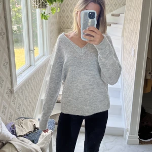 Grå stickad tröja  - Jag säljer en fin stickad tröja från jeansbolaget med V-ringning. Tröjan är i fint skick och sparsamt använd. Jag säljer den pga råkade köpa två likadana Nypris: 500🥰