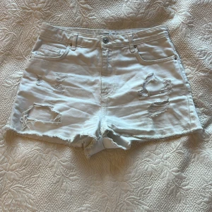  Vita shorts som är rivna  -  har använt några få gånger men ser så helt ny ut. Men finns en liten osynlig svart fläck där bak men den syns inte alls.