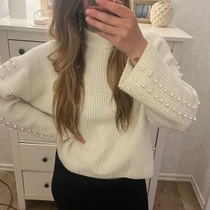 Stickad tröja med pärlor - Hejsan, jag säljer en jättefin vit stickad tröja från H&M. Jag köpte tröjan för länge sen och är tveksam på om den fortfarande säljs. Tröjan är i jättefint skick och bara använd ett fåtal gånger. Jättesöt stickad tröja med vita pärlor vid armarna🤍🤍🤩🤩