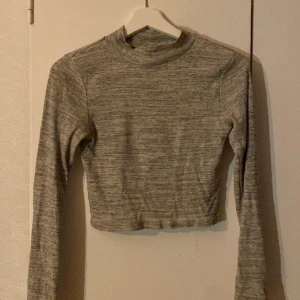 Långärmad tröja - Grå långärmad, croppad tröja. Är använd, men ändå i bra skick