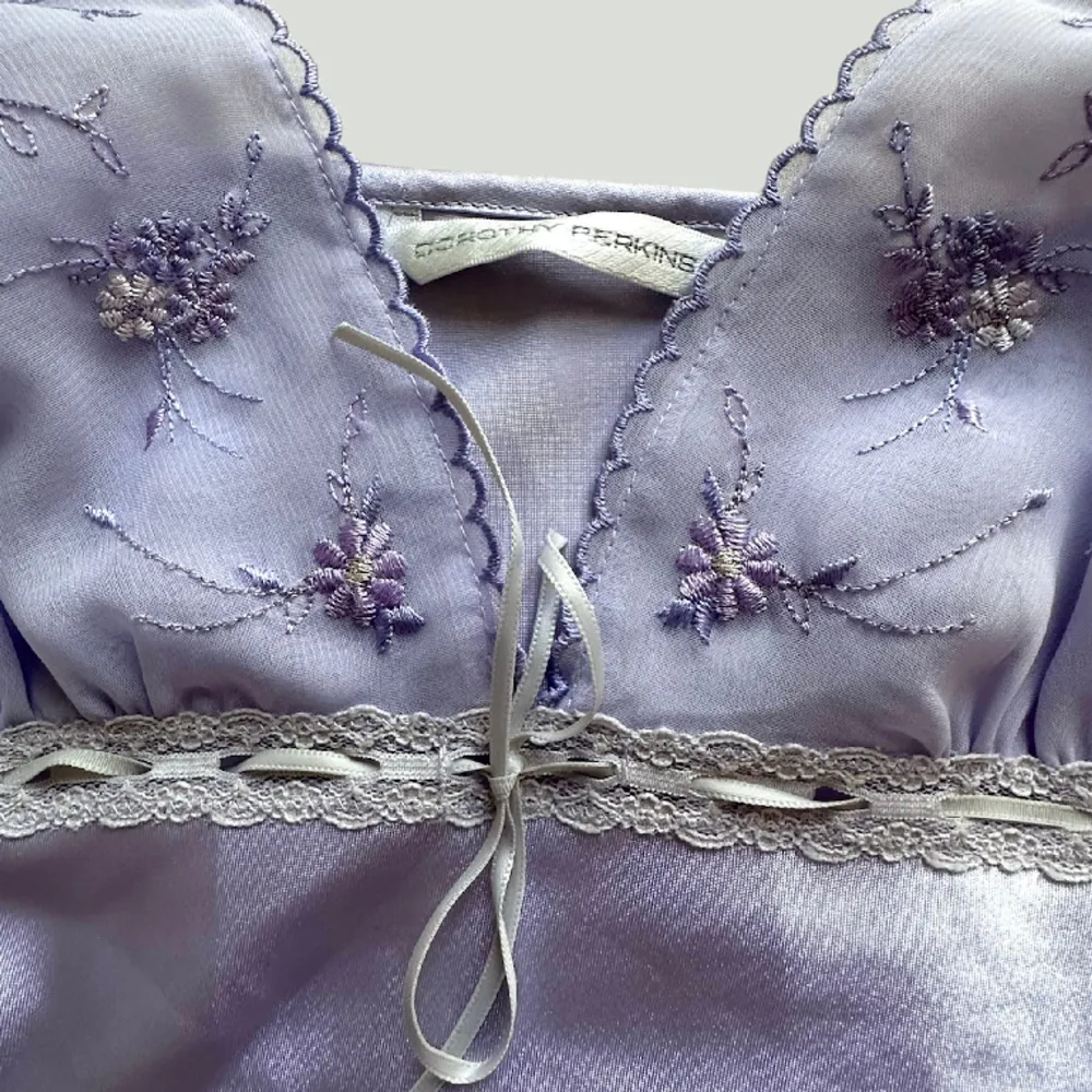 Kort silkesklänning med broderade blommor & rosett🎀Reglerbara axelband. Fint skick, inga defekter! . Klänningar.
