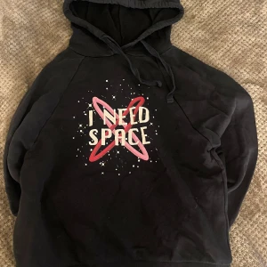Hoodie - En svart hoodie med ”i need my space” på.