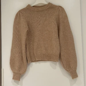 Beige stickad tröja  - En fin stickad tröja från NA-KD i strl xxs. Den är har lite ballongformade ärmar. Säljer då jag inte använder den. Har inte använt den mer än två gånger.  Kom privat för fler bilder/frågor. FRAKT TILLKOMMER!  Skickar ENDAST med postens blåa påsar.  