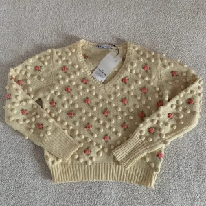 ZARA krämvit stickad tröja med rosor (handcrafting) - Aldrig använd. Ny med tags kvar. Obs: Färgen är krämvit men den ser lite gul ut för att bilderna är tagna i kvällsljus. 🥹