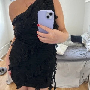 Svart klänning med volanger   - Super snygg svart klänning med volanger från Zara. Oanvänd med prislapp kvar!!!! Storlek M men passar mig som vanligt vis har S. Den är stretchig🤗