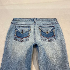 low/midwaist bootcut jeans med snygga detaljer💕 - tyvärr alldeles för stora på mig så går inte att visa accurate hur de ska sitta men de är lowwaist/midwaist och har bootcut👍midja 92 hela runt o innerben 80 cm 