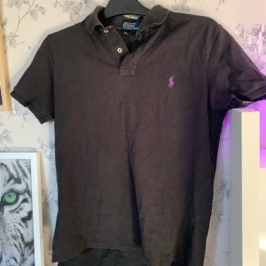 Ralph lauren piké - Svart ralph lauren piké! Köptes i sommarn och använd typ 3-4ggr. Lite urtvättat färg men annars chill! Skriv om du har frågor!👍🤝