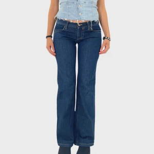 41. Lågmidjade utsvängda jeans -  41. Lågmidjade utsvängda jeans  Midja: 36 cm Innerbenslängd: 72 cm  Modellen är 158 cm lång och bär vanligtvis storlek 34   