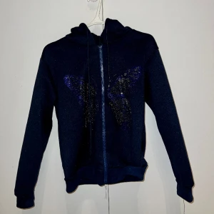 Zip up hoodie med glitter tryck - Mörkblå/svart hoodie med luva och en glittrig fjärilmotiv 3D STRL S