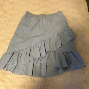 Ljusblå volangkjol - Ljusblå volangkjol från nellybynelly i storlek s, använd få gånger och är i fint skick. Säljer då jag växt ur den.