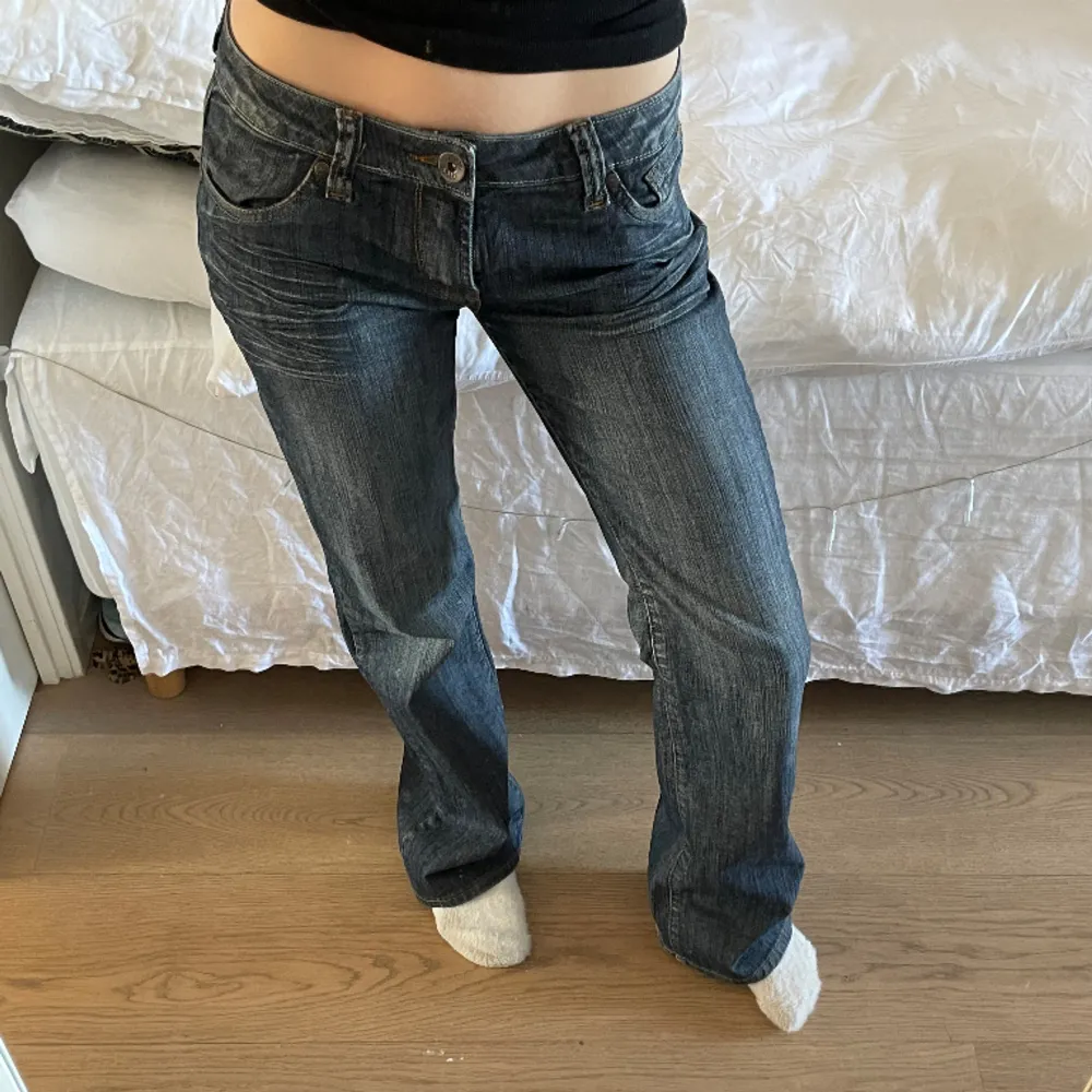 Låg midjade mörk blå jeans med stenar/kristaller på fickorna  Måtten är:  Midja - 39 cm  Innerbenslängd längden - 83cm  Ben längd - 103 cm . Jeans & Byxor.