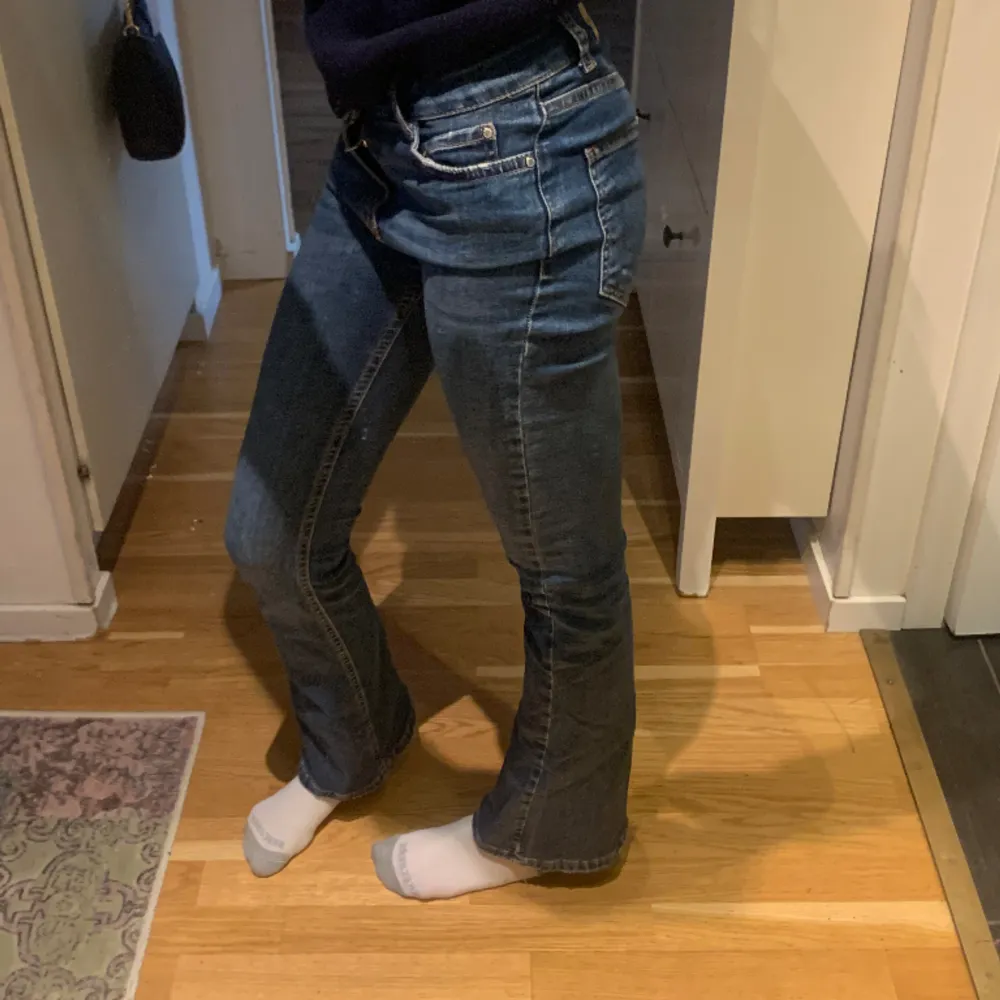 Ett par mörblåa jeans från Gina tricot. Lågmidjade och utsvängda.  Midjemått:32cm Innerbenslängd: 75cm. Jeans & Byxor.