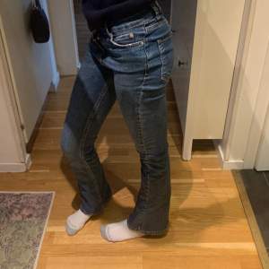 Ett par mörblåa jeans från Gina tricot. Lågmidjade och utsvängda.  Midjemått:32cm Innerbenslängd: 75cm