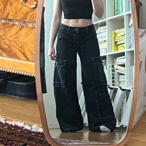 Lågmidjade vida jeans - Så snygga lågmidjade, vida, cargo jeans. Helt nya med lappen kvar (endast testade). Storlek 1 vilket jag skulle tro motsvarar xs/s❣️Köpta för ungefär 400-500kr